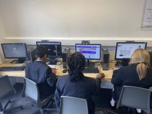 Photo of high school children in a classroom playing TT Rock Stars on desktops.